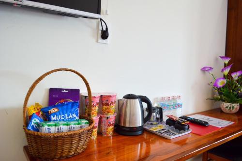 - une table avec un panier de collations et une cafetière dans l'établissement Biển Xanh Hotel Quy Nhơn, à Quy Nhơn