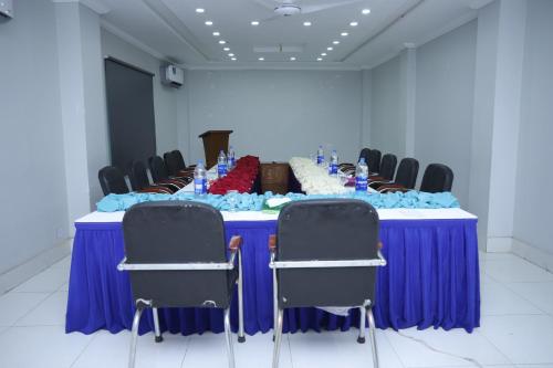 a long blue table with chairs in a room at Hotel Crown Inn Multan in Multan