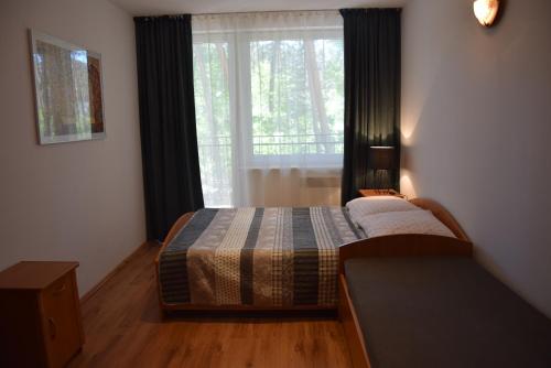 a bedroom with a bed in front of a window at Apartament 101 Blue Mare in Łukęcin