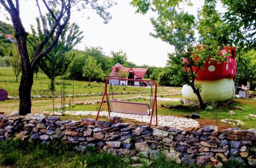 a playground in a garden with a rock wall at Krka Fairytale village in Rupe