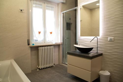 a bathroom with a sink and a tub and a window at La Corte di Aldo in Rozzano