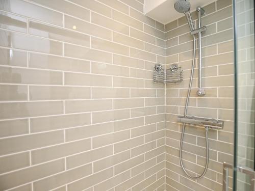 IdburyにあるWashpoolの白いタイル張りのシャワー(シャワーヘッド付)
