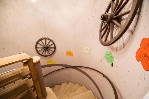 a room with a bed with a wheel on the wall at Hostel Paradiso in Tolmin