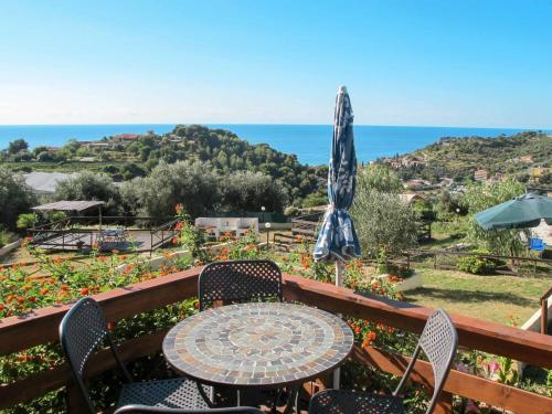 einen Tisch und Stühle auf einem Balkon mit Sonnenschirm in der Unterkunft Holiday Home Le Terrazze del Geco Bungalow A - SLR300 by Interhome in San Lorenzo al Mare