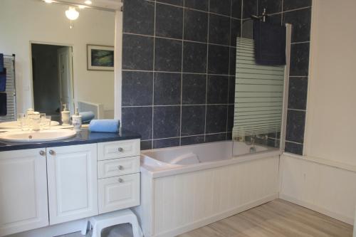ein Badezimmer mit einer Badewanne und einem Waschbecken in der Unterkunft Le Jardin Sarlat in Sarlat-la-Canéda