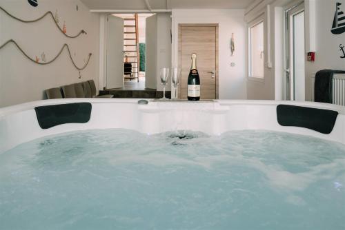 - un bain à remous dans une chambre avec une bouteille de vin dans l'établissement Zythogite Appartement 9 personnes, jardin, bbq, à Tintigny