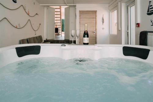 a hot tub in a room with a bottle of wine at Zythogite, 23 personnes, 9 chambres, 6 salles de bain, bbq, jacuzzi, jardin, billard in Tintigny
