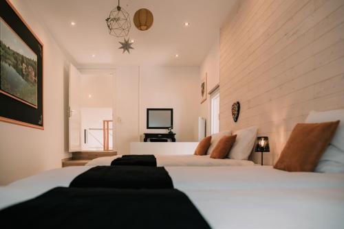 a bedroom with two white beds and a television at Zythogite, 23 personnes, 9 chambres, 6 salles de bain, bbq, jacuzzi, jardin, billard in Tintigny