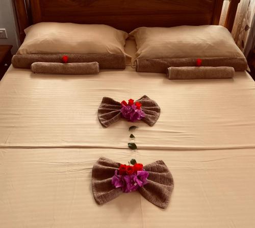 a bed with bows on top of it at Erica's Self Catering Apartment in Mahe