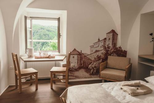 a bedroom with a bed and a desk and a window at Rooms & Apartments Podsreda Castle in Podsreda