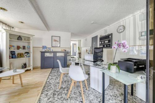 Il comprend une cuisine avec un bureau et deux chaises blanches. dans l'établissement Hôtel Vila, à Frontignan