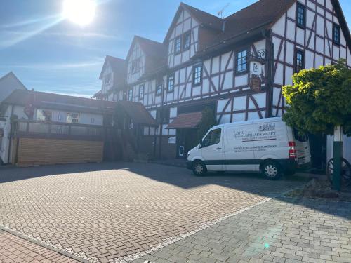 ein weißer Van vor einem Gebäude geparkt in der Unterkunft Hotel-Gasthaus-Kraft in Schauenburg