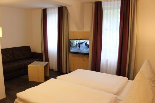 a hotel room with two beds and a television at Hotel-Gasthaus-Kraft in Schauenburg