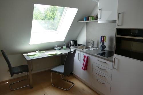 a small kitchen with a table and a window at kleine Ferienwohnung am Wulfkamp in Velen