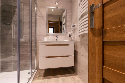 uma casa de banho com um lavatório e um chuveiro em Apartamenty u Semlów em Szaflary
