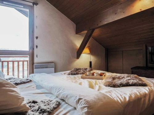 een groot wit bed in een kamer met een raam bij Le Cairn in Peisey-Nancroix