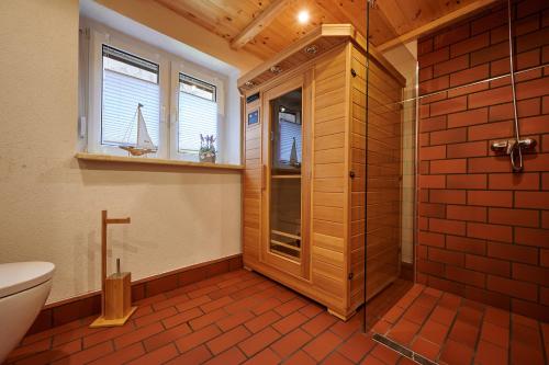 a bathroom with a shower and a toilet and windows at Radler Pension Wettin in Wettin