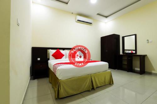 a bedroom with a bed with a red sign on it at SH Hotel in Ras al Khaimah