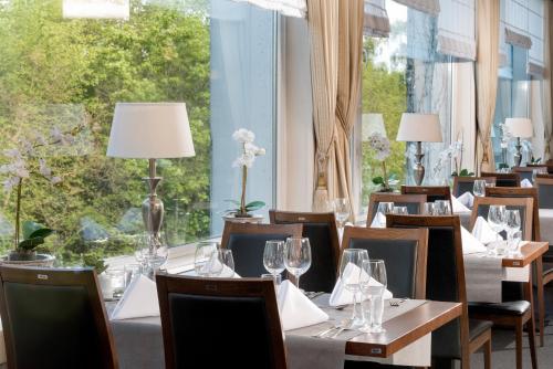 a restaurant with tables and chairs and a large window at Hotel des Nordens Flensburg Wellness & Spa in Flensburg