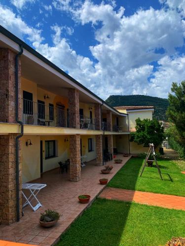 a courtyard of a building with a lawn at Hotel La Ciaccia in Valledoria