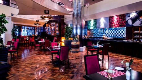 a restaurant with tables and chairs and a bar at Crowne Plaza Dubai Deira by IHG in Dubai