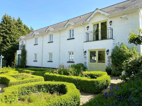 a house with hedges in front of it at Ballyknocken Milking Parlour Self Catering Apartment in Coolnakilly