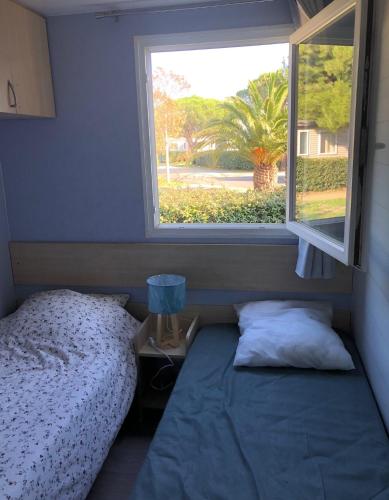 une chambre avec un lit et une fenêtre dans l'établissement Mobil home 4 personnes Port la nouvelle, à Port-la-Nouvelle
