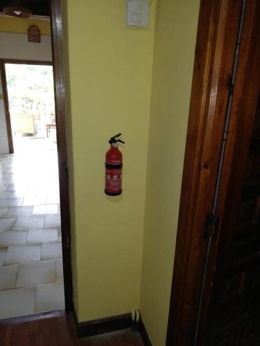 a fire extinguisher on the wall of a room at Garai Etxea, casa adosada en la montaña in Arrankudiaga