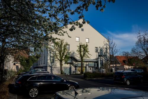 a white building with cars parked on a street at Börse Coswig in Coswig
