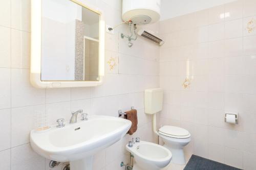 a white bathroom with a sink and a toilet at APARTMENTS GASSER - Apartment 2 in Caorle