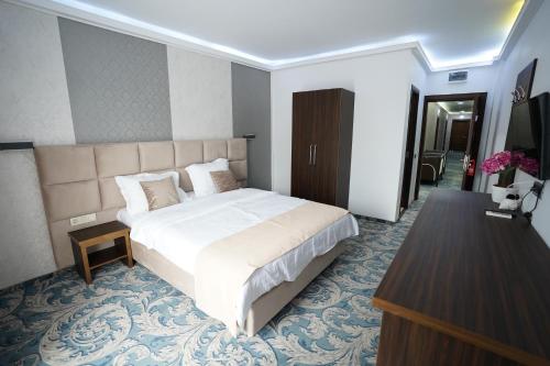 a hotel room with a large bed and a desk at Hotel AquaMarine in Costinesti