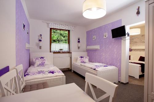 a room with two beds and a dining room at Wellness penzion Harmonie Rohanov in Prachatice