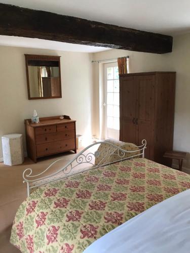 a bedroom with a bed and a dresser and a window at Chambres d'Hôtes Belle Vallee in Domfront