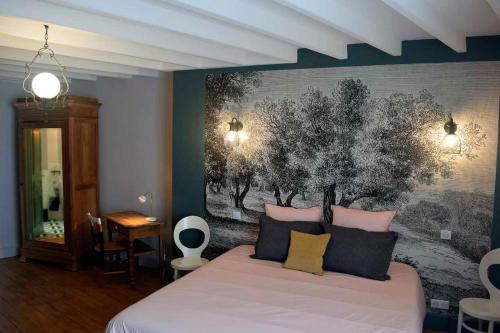 a bedroom with a bed with a painting on the wall at Chambres d'hôtes Coté Halles in Pamproux