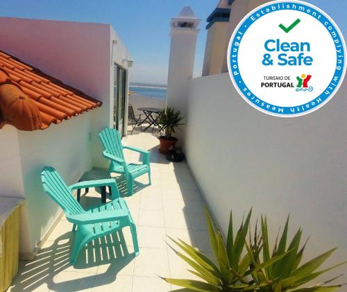a patio with chairs and a sign that reads clean and safe at Peniche Surf Lodge 2 in Peniche