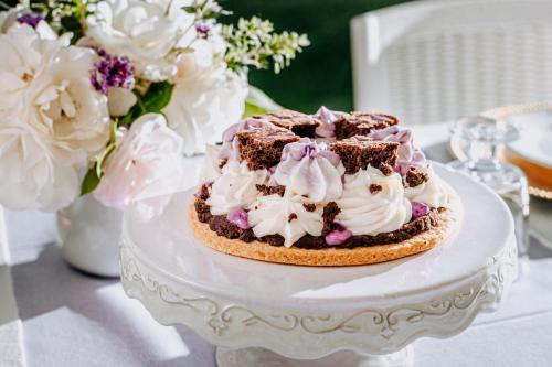 a cake on a white table with flowers and flowers at Alle Pendici del Conero in Sirolo