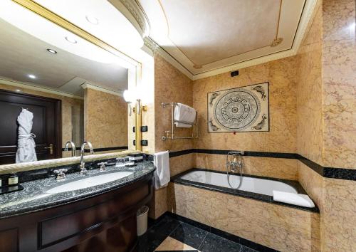 
a bathroom with a tub, sink and mirror at River Chateau Hotel in Rome
