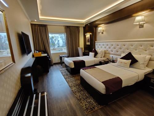 a hotel room with two beds and a television at Zone by The Park, Jammu in Jammu