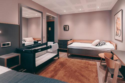 a room with two beds and a table and a mirror at Centro Hotel Turku in Turku