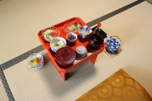 una bandeja de comida y platos en una mesa en Gyokuzoin, en Heguri