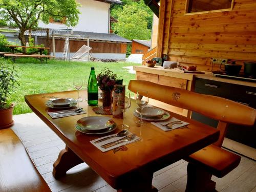 una mesa de madera con platos y vasos. en Apartment and Garden house among the mountains, en Podbrdo