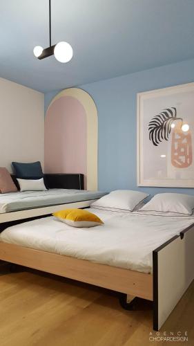 une chambre avec deux lits et un tableau au mur dans l'établissement T2 L'ArtDéco - Parking - Quartier Vivant, à Strasbourg