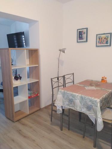 Zimmer mit einem Tisch und einem Bücherregal in der Unterkunft Apartments Zlatko in Pula