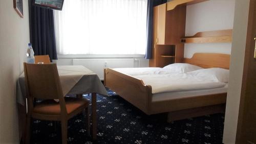 um quarto com uma cama, uma mesa e uma janela em Hotel Zur Traube em Bad Homburg vor der Höhe