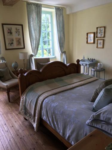 a bedroom with a large bed and a window at Chambres d'Hôtes Belle Vallee in Domfront