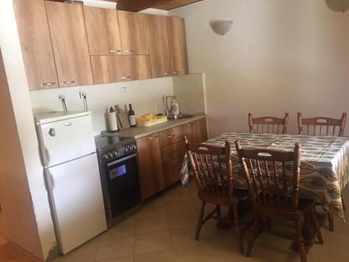 a kitchen with a table and a white refrigerator at Durmitorska kuća in Žabljak