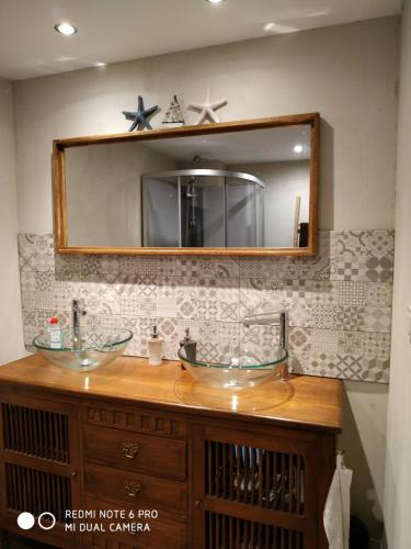 een badkamer met 2 wastafels en een spiegel bij lesfilatures in Saint-Vincent-de-Reins