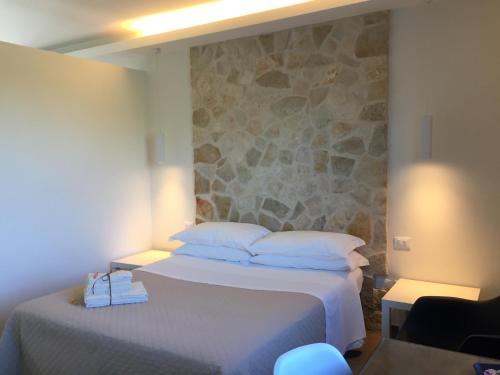 een hotelkamer met een bed en een stenen muur bij Ranieri Events and B&B in Casacanditella