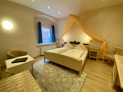 a bedroom with a bed with a canopy at Hotel Deutsches Haus in Dinkelsbühl