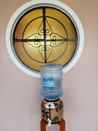 a water bottle on a wooden stand with a window at Hotel Ojo de Agua in Ciudad Hidalgo